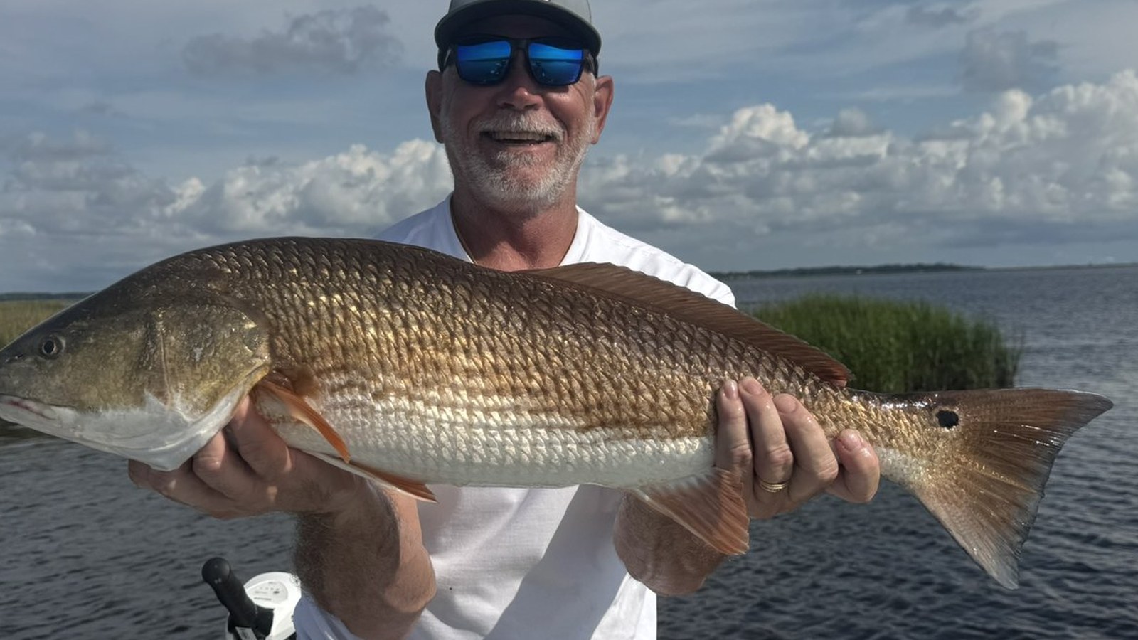 Angler holding a large redfish caught near Pumpkin Hill Creek
